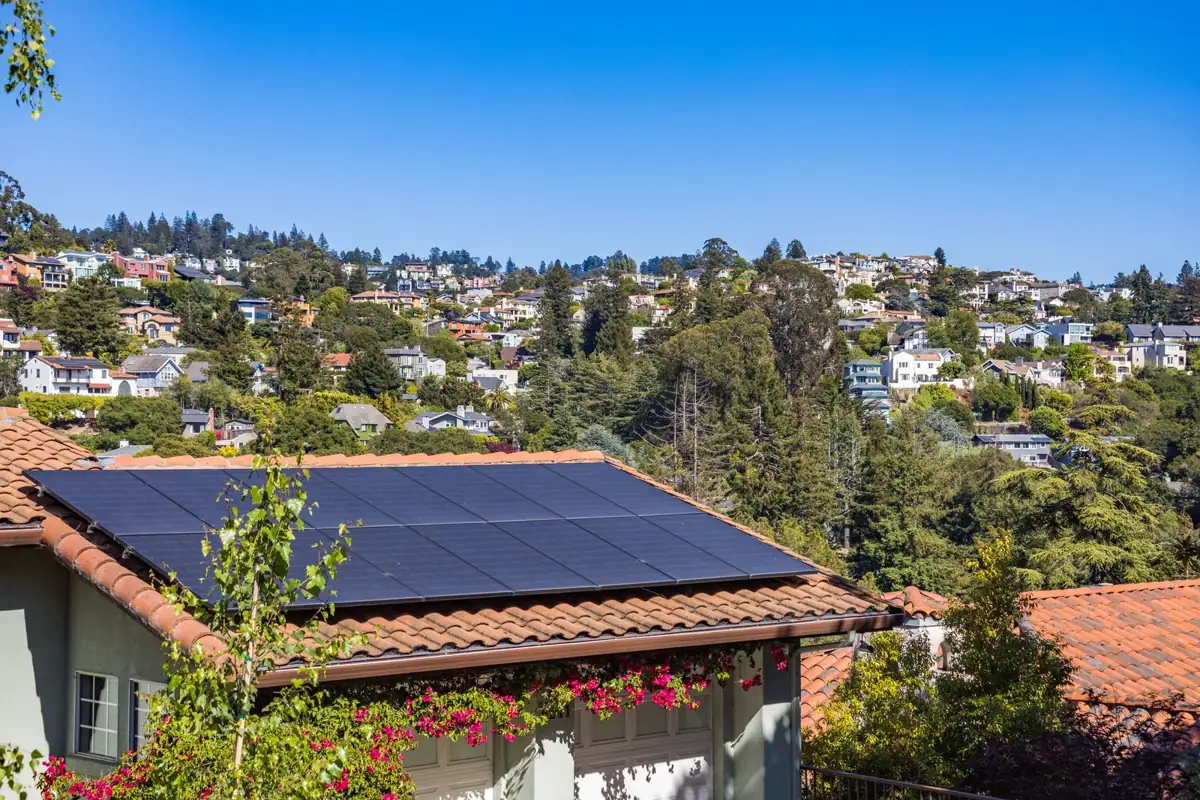 Home with rooftop solar panels on a hillside